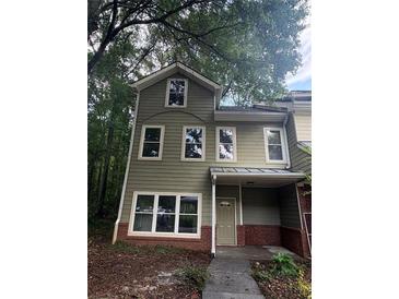Charming two-story home with light green siding, brick accents, and large windows at 101 Dancing Fox Rd, Decatur, GA 30032