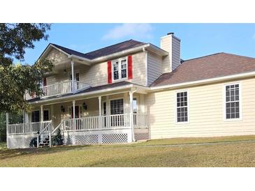 Charming two-story home with a welcoming porch and a second-story balcony and a red-shuttered window at 4335 Commodore Rd, Powder Springs, GA 30127