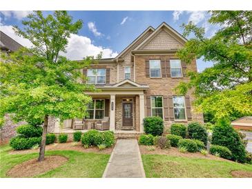 Beautiful two-story home with manicured lawn, stone accents, and a welcoming front porch at 4895 Sterling Close, Buford, GA 30518