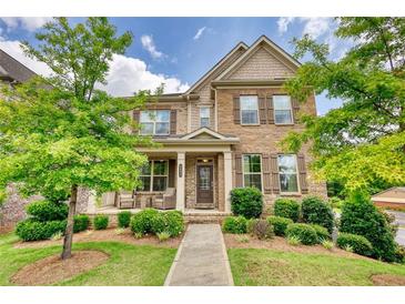 Charming two-story home with a stone and siding facade, beautiful landscaping and a welcoming front porch at 4895 Sterling Close, Buford, GA 30518