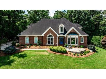 Charming brick home featuring a lush green lawn and mature trees at 215 Settindown Ct, Roswell, GA 30075