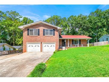 Two-story brick home with a well-manicured lawn, two-car garage, and covered porch at 2117 Chestnut Hill Circle Cir, Decatur, GA 30032