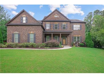 Inviting brick two-story home featuring manicured lawn and symmetrical architectural details at 4547 Meadow Green Nw Ln, Acworth, GA 30101