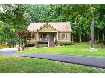 Charming single Gathering home featuring a quaint front porch with beautiful lawn and mature trees at 325 Harris Loop, Dallas, GA 30157