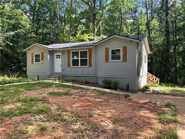 Charming single-story home with gray siding and wooden shutters nestled among mature trees at 4610 Wilson James Sw Rd, Atlanta, GA 30331