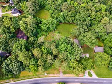 An aerial view shows the expansive lot surrounded by mature trees and greenery at 4459 Flat Shoals Pkwy, Decatur, GA 30034