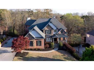 Beautiful brick home featuring well-maintained landscaping and a welcoming front porch at 610 Big Bend Trail, Sugar Hill, GA 30518