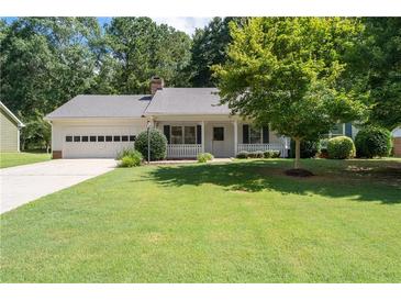 Charming single-story home featuring an attached garage, manicured lawn, and inviting front porch at 334 Bridgewood Se Dr, Conyers, GA 30094
