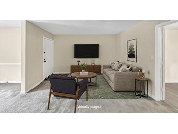 Cozy living room featuring a plush sofa, stylish decor, and a large TV at 58 Monet Nw Ct, Atlanta, GA 30327