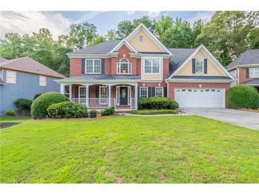 Charming two-story brick home with a welcoming front porch and well-manicured lawn at 1172 Oakhurst Trl, Lawrenceville, GA 30043