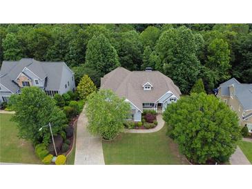 Beautiful home with well-manicured lawn, mature trees, a long driveway, and a three-car garage at 130 Holly Reserve Pkwy, Canton, GA 30114