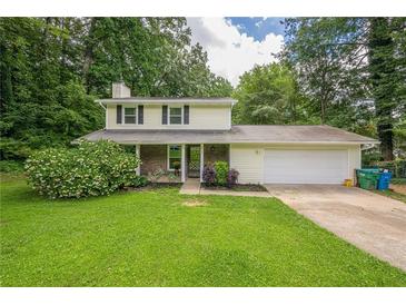 Traditional two-story home featuring a landscaped front yard and attached garage at 5868 Kingswood Nw Ct, Norcross, GA 30093