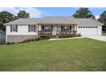 Charming single-story home featuring a welcoming front porch and well-manicured lawn at 1250 Timber Walk Dr, Loganville, GA 30052