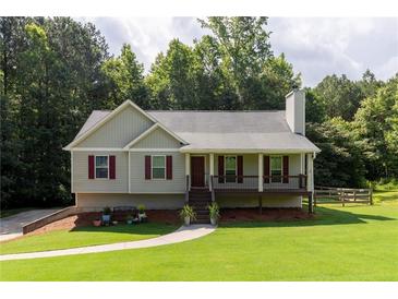 Charming single-story home with a well-maintained lawn, inviting porch, and colorful landscaping at 19 Autumn Ne Pl, White, GA 30184
