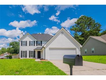 Charming two-story home featuring a well-manicured lawn and classic white siding at 5916 Farmbrook Ln, Rex, GA 30273