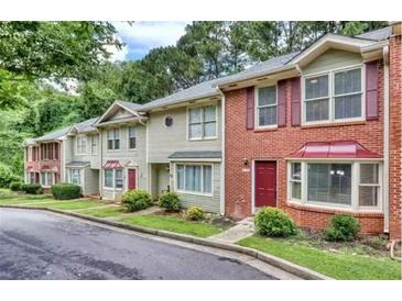 Inviting townhome with manicured lawns and colorful landscaping features at 306 Autumn Leaf Way, Norcross, GA 30093
