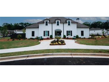 Elegant white brick home featuring a well-manicured lawn, symmetrical landscaping, and a charming entryway at 3579 Silvery Way, Powder Springs, GA 30127