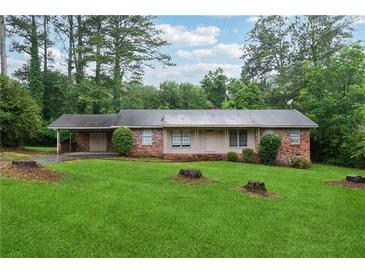 Charming brick home with a spacious front yard and mature trees offers classic curb appeal at 1913 Ferry Dr, Marietta, GA 30066