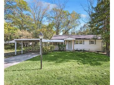 Charming one-story home featuring a carport and a well-maintained lawn at 1703 Barrett Nw Dr, Atlanta, GA 30318