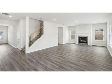 Bright and spacious living room features luxury vinyl plank floors, a fireplace, and lots of natural light at 386 Tallulah Ln, Grayson, GA 30017