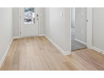 Bright entryway with wood-look flooring and a white front door provides a warm welcome to the home at 1539 High Falls Ln, Grayson, GA 30017