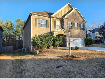 Charming two-story home with brick and siding exterior and well-maintained landscaping in a suburban setting at 5150 Amberland Sq, Atlanta, GA 30349