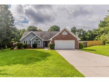 Charming single Gathering home featuring a brick facade, attached garage, and a well-manicured front lawn at 250 Meadow View Dr, Grayson, GA 30017