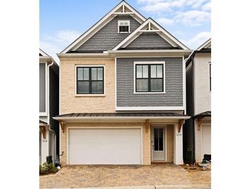 Charming two-story home featuring stone and gray shingle siding, a two-car garage, and a welcoming front door at 114 Batten Board Way, Woodstock, GA 30189