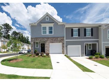 Two-story townhome features a one-car garage and manicured lawn at 3554 Bluebird Ct, Atlanta, GA 30331