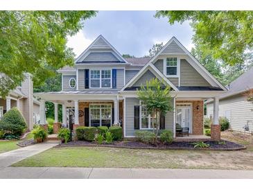 Charming two-story home with a welcoming front porch and manicured landscaping at 3900 Baluster Ct, Suwanee, GA 30024