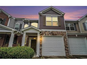 Charming townhome featuring stone accents, a covered entrance, and an attached one car garage at 2731 Pierce Brennen Ct, Lawrenceville, GA 30043