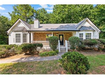 Charming ranch-style home featuring a stone facade, well-maintained landscaping, and a welcoming front porch at 165 Lost Lake Trl, Villa Rica, GA 30180