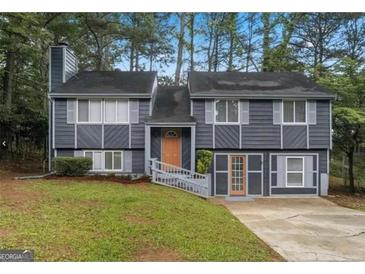 Charming two-story home with gray siding, mature trees, and a welcoming entrance at 2106 Singer Way, Lithonia, GA 30058