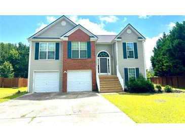 Charming two-story home featuring a two-car garage, brick accents, and a well-manicured front lawn at 203 Galway Ln, Hampton, GA 30228