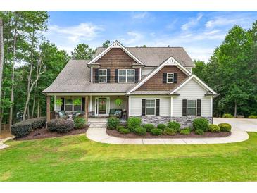 Charming home featuring stone accents, a cozy front porch, and a well-manicured lawn and landscaped garden at 510 Black Horse Cir, Canton, GA 30114
