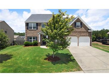 Charming two-story brick home featuring a well-manicured lawn and a two-car garage at 303 Horizon Trce, Loganville, GA 30052