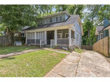 Charming two-story home featuring a screened-in front porch and mature trees at 1454 Beecher Sw St, Atlanta, GA 30310