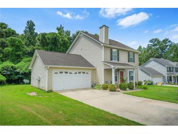 Charming two-story home featuring an attached garage, well-maintained lawn and manicured landscaping at 30 Creek Bottom Dr, Covington, GA 30014