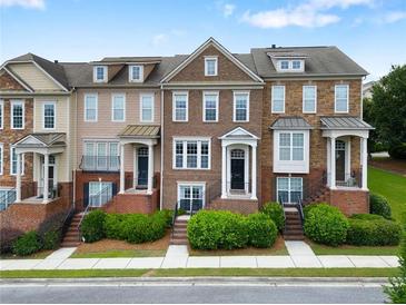 Charming townhome exterior featuring brick accents, manicured landscaping, and inviting entrances at 2367 Millhaven Se St, Smyrna, GA 30080