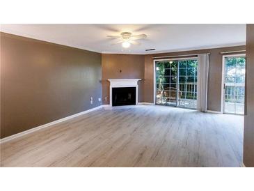 Spacious living room featuring a fireplace, and access to the outdoor patio at 3396 Misty Harbour Trl, Doraville, GA 30340