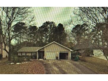Charming single-story home with a two-car garage and mature trees surrounding the property at 791 Bristol Way, Lithonia, GA 30058