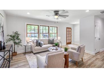 Bright living room features large windows, light colored walls, and wood-look floors at 911 Oakland Sw Dr, Atlanta, GA 30310