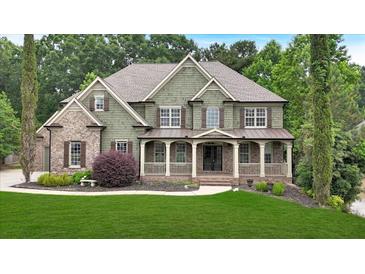 Charming two-story home with a covered porch and well-manicured lawn at 511 Millwood Ct, Canton, GA 30114