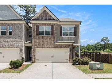 Charming two-story townhome with brick accents, attached garage, and well-manicured landscaping at 2700 Norwich Trce, Snellville, GA 30078