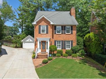 Charming brick home with lush lawn, manicured landscaping, and an inviting brick walkway at 3120 Henderson Walk, Atlanta, GA 30340