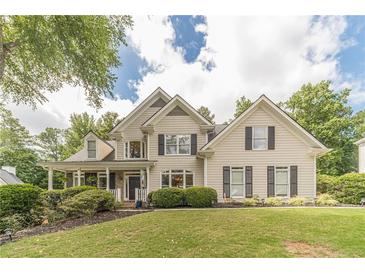 Charming two-story home with manicured lawn, mature trees, and classic architectural details at 1461 Radstone Dr, Lawrenceville, GA 30044
