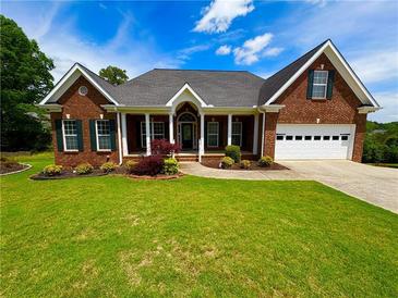 Charming brick home with a well-manicured lawn and a welcoming front porch at 3426 Olivia Grace Way, Dacula, GA 30019