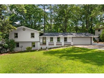 Charming updated home with a beautiful lawn, painted white brick and newer contrasting windows at 4214 Williamsburg Dr, College Park, GA 30337
