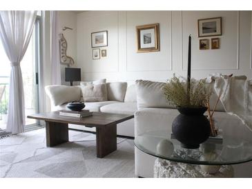 Bright living room features neutral décor, plush sofa, and large windows with sheer curtains at 711 Cosmopolitan Dr # 413, Atlanta, GA 30324