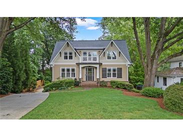 Charming two-story home featuring a manicured lawn, mature trees, and inviting curb appeal with a second story balcony at 2697 N Thompson Ne Rd, Atlanta, GA 30319